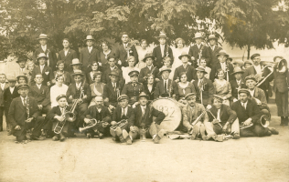 Kuchařovice rok 1932 – zavádějící chasa s muzikanty z posvícení. Muž s prázdným tuplákem piva v popředí je družba, s největší pravděpodobností tehdy vyhlášený Antonín Bulín. foto: archiv Jihomoravského muzea Znojmo
