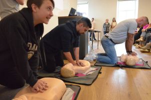 Dva dobrovolníci soutěží s Markem Dvořákem v resuscitaci. Vlevo dvanáctiletý Michael Jajtner.